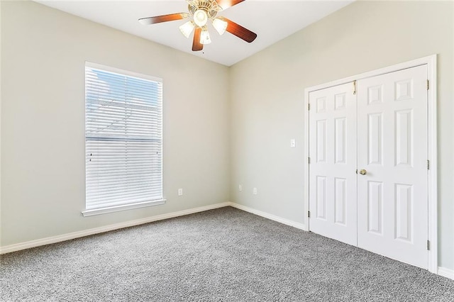 spare room with ceiling fan, carpet floors, and baseboards