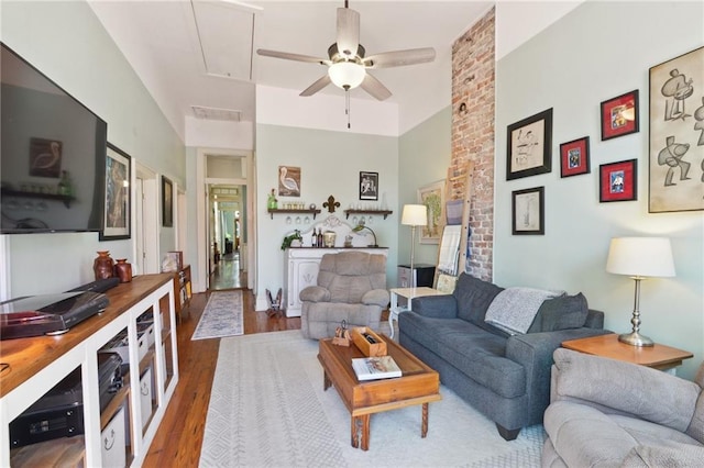 living area with visible vents, wood finished floors, attic access, and a ceiling fan