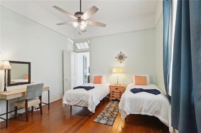 bedroom with dark wood-type flooring and baseboards