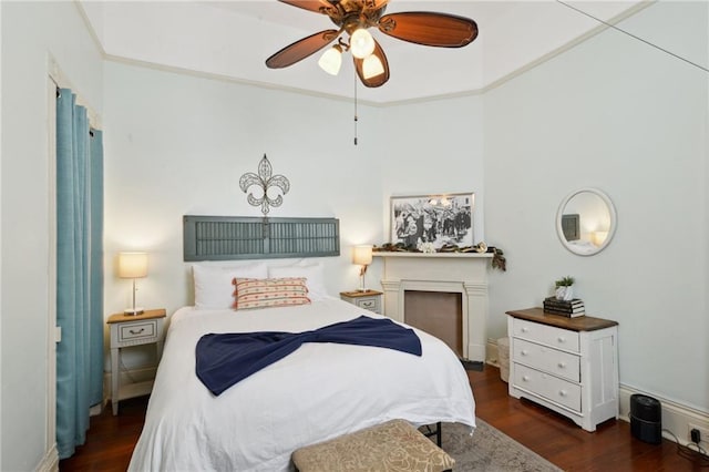 bedroom with dark wood-style floors, ornamental molding, and a ceiling fan