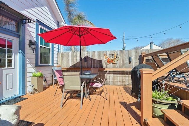 wooden terrace with outdoor dining space and fence