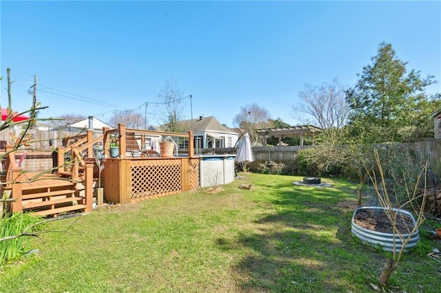 view of yard featuring a fenced backyard, a fire pit, a fenced in pool, and a wooden deck