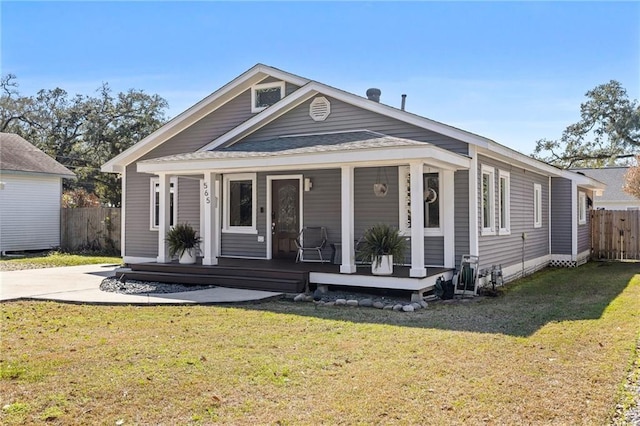 view of front of house with a front lawn, fence, and a porch