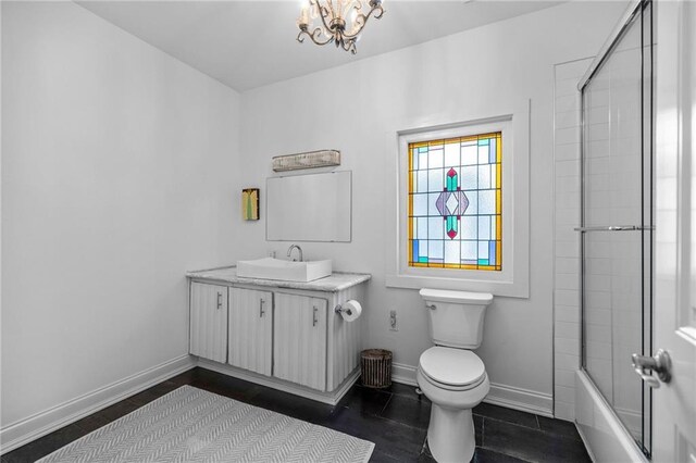 full bathroom featuring enclosed tub / shower combo, toilet, vanity, baseboards, and an inviting chandelier