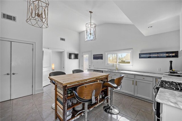 kitchen with gas range, visible vents, light countertops, and a sink