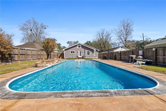 view of swimming pool with a fenced backyard, a patio, a fenced in pool, and an outdoor structure