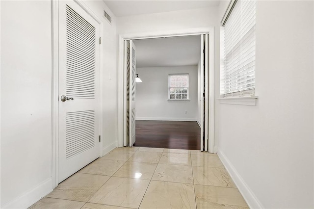 hall with visible vents and baseboards