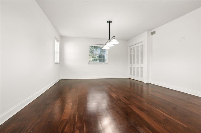 unfurnished dining area with visible vents, baseboards, and dark wood-style floors