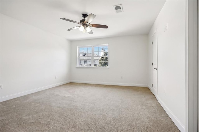 spare room with light carpet, visible vents, baseboards, and a ceiling fan