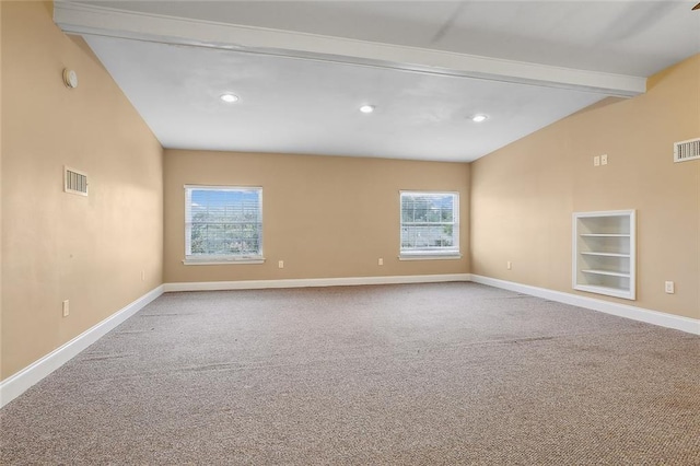 empty room featuring a wealth of natural light, visible vents, and carpet flooring