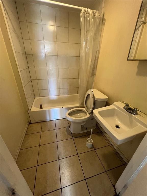 full bathroom featuring toilet, baseboards, a sink, and tile patterned floors