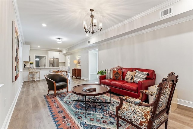 living room featuring visible vents, baseboards, an inviting chandelier, light wood-style floors, and crown molding