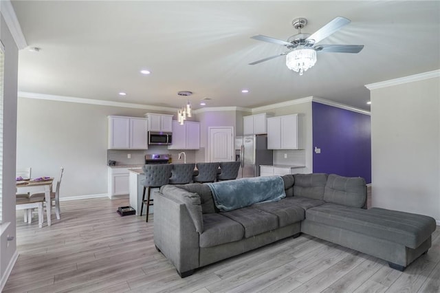 living room featuring ornamental molding, recessed lighting, light wood-type flooring, and baseboards