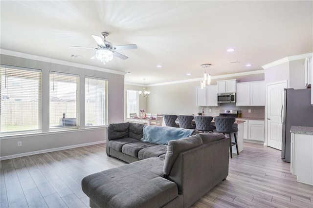 living area featuring light wood-style floors, visible vents, crown molding, and baseboards