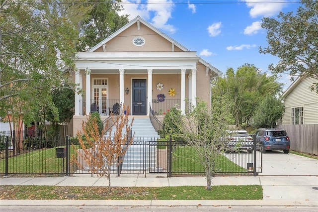 view of front of house featuring a fenced front yard, a porch, concrete driveway, and stucco siding