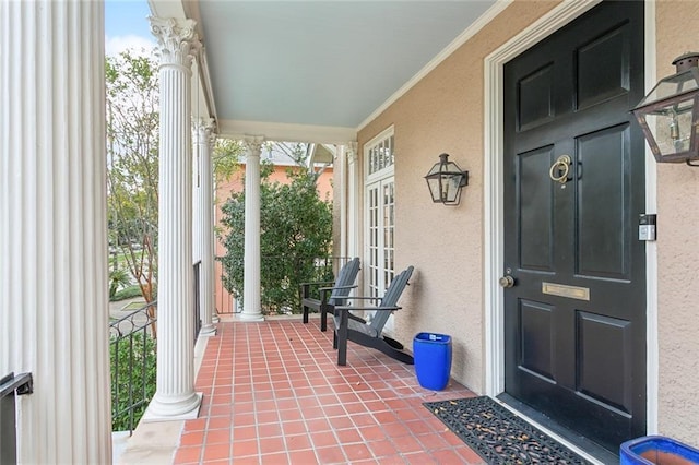 entrance to property featuring a porch and stucco siding