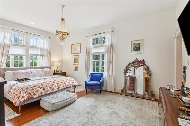 bedroom with a chandelier, recessed lighting, wood finished floors, and baseboards