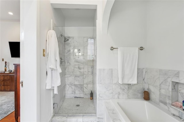 bathroom featuring a garden tub and a shower stall