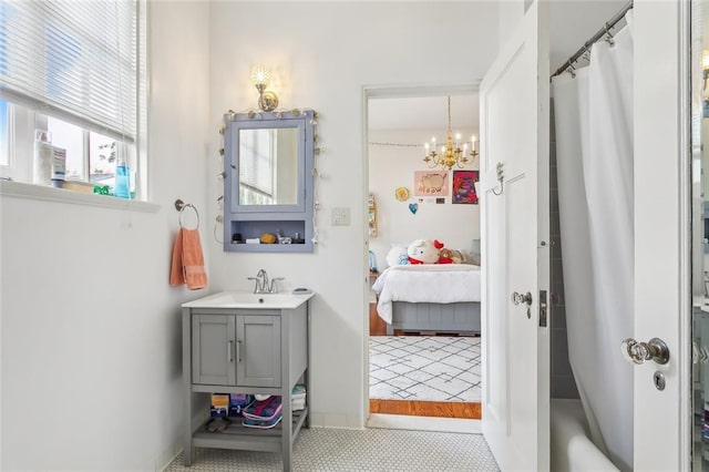 ensuite bathroom featuring connected bathroom, vanity, and an inviting chandelier