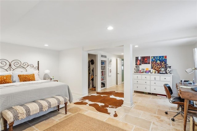 bedroom featuring baseboards, stone tile floors, and recessed lighting