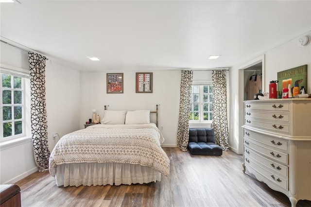 bedroom with light wood-type flooring and baseboards