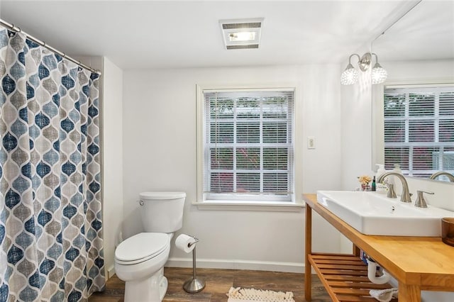 full bath featuring baseboards, visible vents, toilet, wood finished floors, and vanity