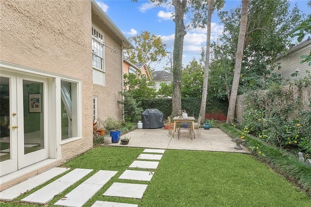 view of yard featuring a patio, french doors, and fence