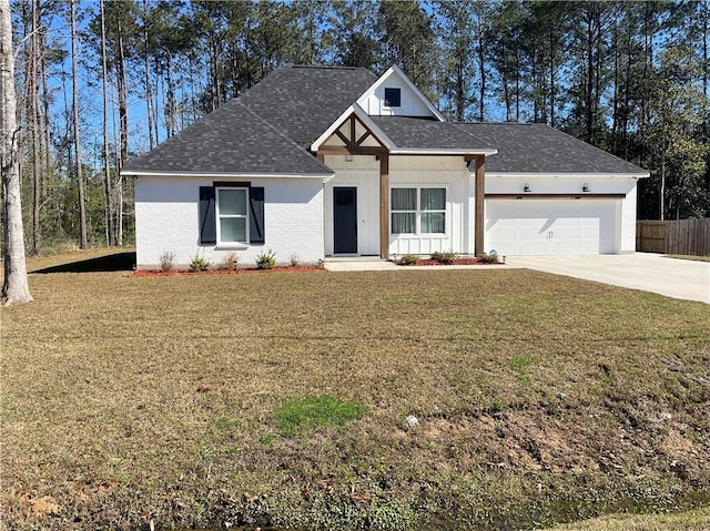 view of front of property with a garage, brick siding, driveway, and a front lawn