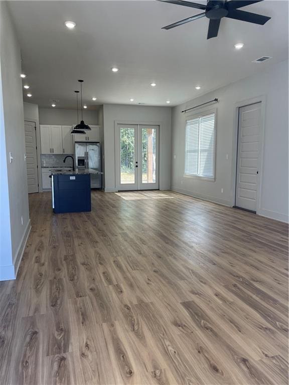 unfurnished living room featuring recessed lighting, visible vents, baseboards, french doors, and light wood finished floors