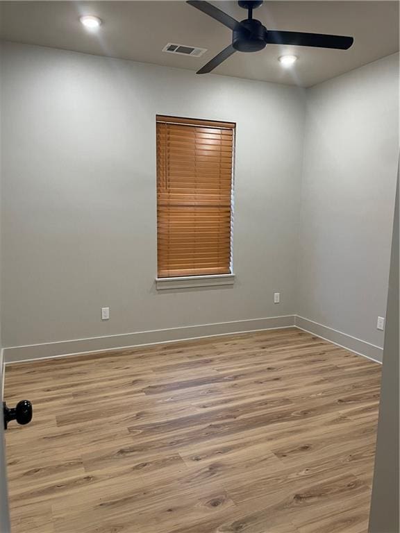 empty room with baseboards, visible vents, ceiling fan, and light wood finished floors