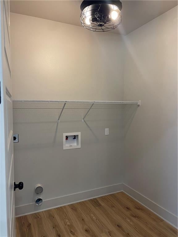 laundry area featuring hookup for a washing machine, laundry area, baseboards, and wood finished floors