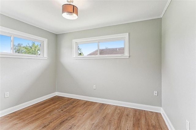 spare room featuring ornamental molding, wood finished floors, and baseboards