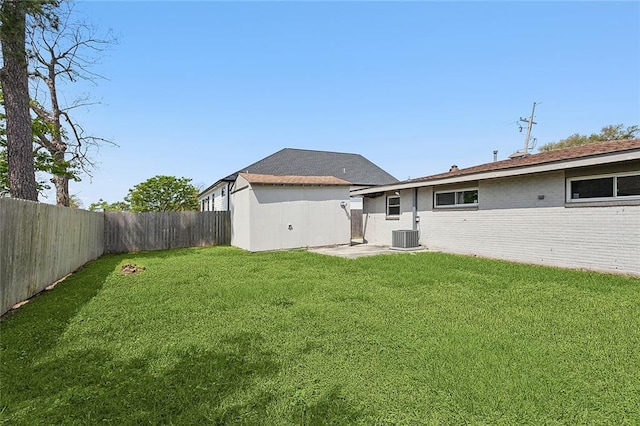 back of property featuring a yard, brick siding, and a fenced backyard