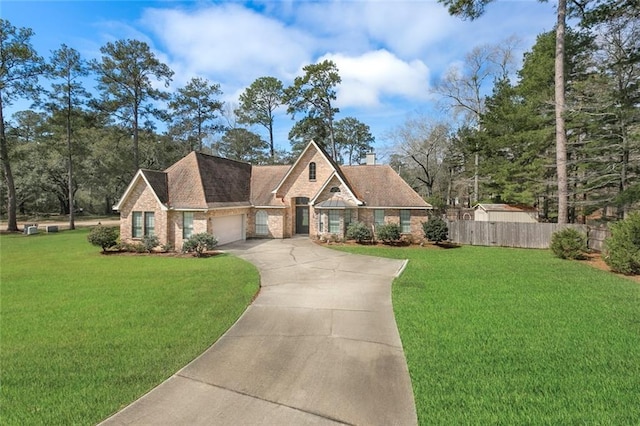 view of front facade with an attached garage, fence, a front lawn, and concrete driveway