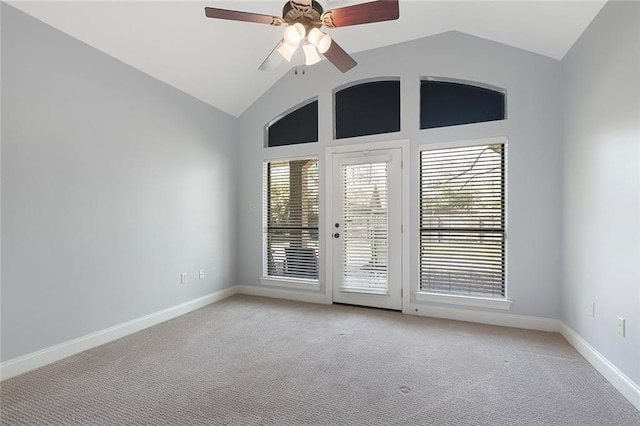 spare room featuring lofted ceiling, baseboards, a ceiling fan, and light colored carpet