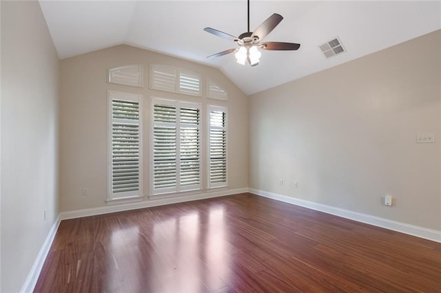 spare room featuring lofted ceiling, ceiling fan, dark wood finished floors, and visible vents