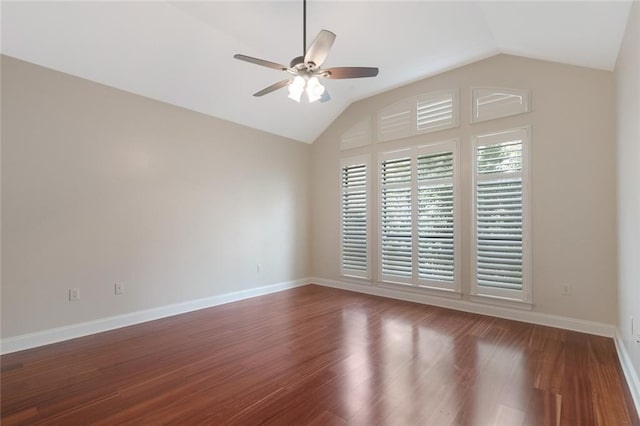 empty room featuring a ceiling fan, dark wood-style flooring, vaulted ceiling, and baseboards