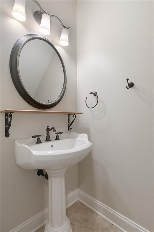 bathroom with a sink, baseboards, and tile patterned floors