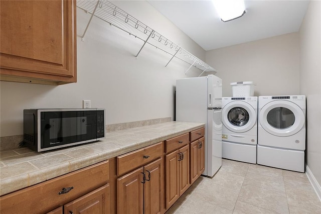 washroom with independent washer and dryer and light tile patterned floors