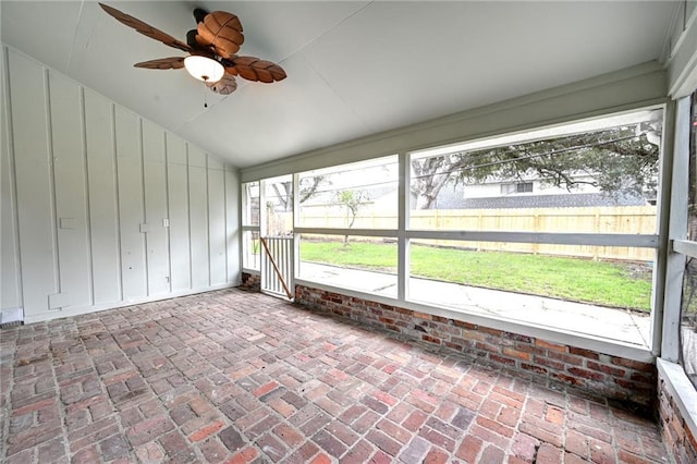 unfurnished sunroom with ceiling fan and vaulted ceiling