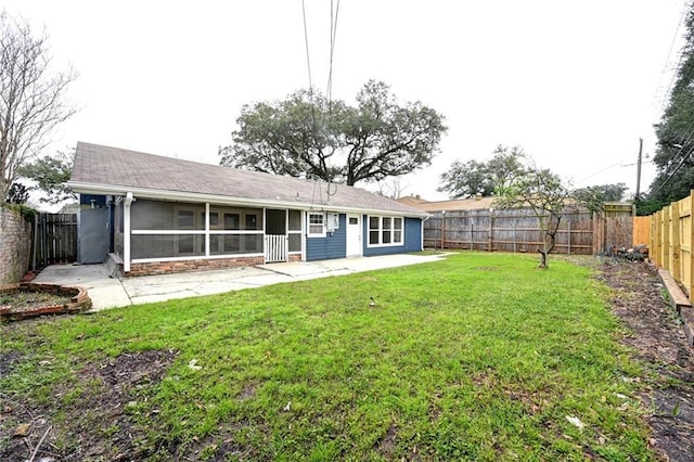 rear view of property featuring a patio area, a sunroom, a fenced backyard, and a lawn