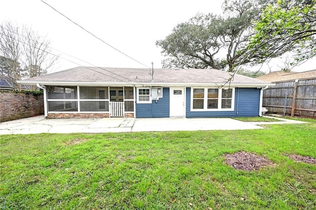 rear view of property with a sunroom, a patio area, a lawn, and a fenced backyard