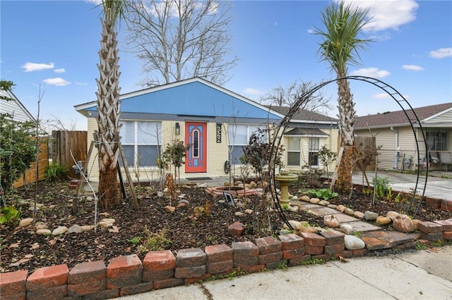 view of front facade with brick siding and fence