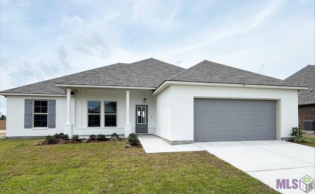 ranch-style home featuring roof with shingles, a garage, concrete driveway, and a front yard