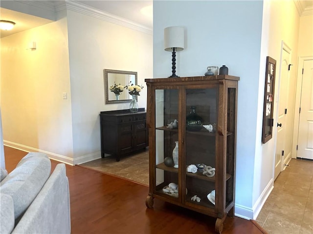 hallway with baseboards, crown molding, and wood finished floors