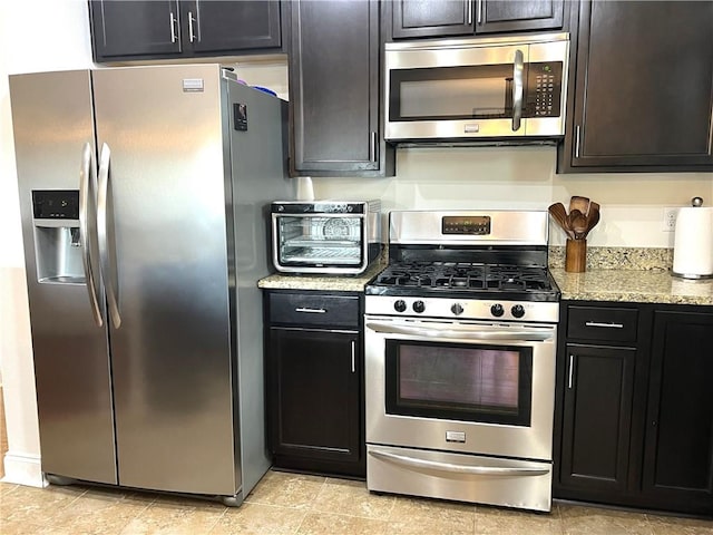 kitchen featuring light stone countertops and appliances with stainless steel finishes