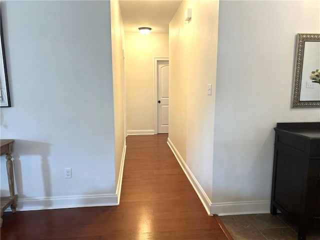 hall featuring dark wood finished floors and baseboards