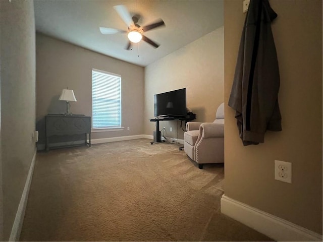 living area featuring carpet, baseboards, and ceiling fan