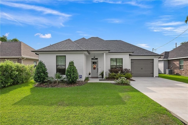 view of front of house featuring a shingled roof, an attached garage, cooling unit, driveway, and a front lawn