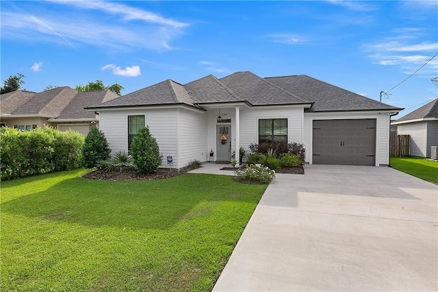 view of front of home featuring a front lawn, roof with shingles, driveway, and an attached garage